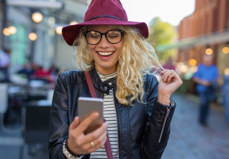 happy woman smiling at search results on smartphone